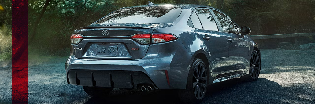 Rear three-quarter view of a grey Toyota Corolla on the road.